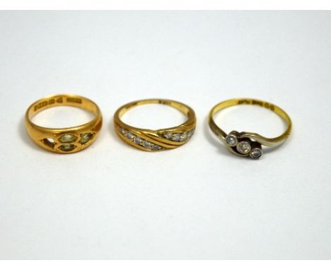 THREE RINGS, the first a 9ct gold diamond band ring, the second an 18ct gold three stone diamond ring together with a gypsy r