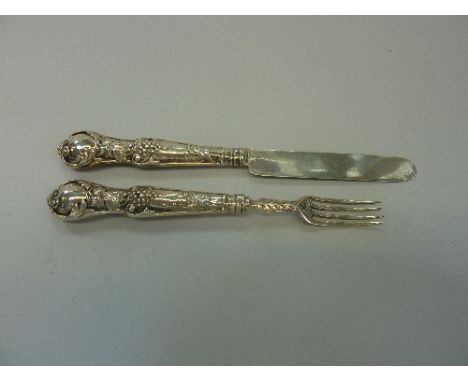 A SILVER KNIFE AND FORK, with decorative handles depicting vine leaves and grapes, hallmarks for Birmingham, makers marks Geo