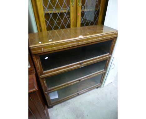 AN OAK GLAZED THREE TIER GLOBE WERNICKE STYLE BOOKCASE