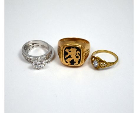 FOUR RINGS, the first a gentlemans ring with emblem of a lion, together with three further rings