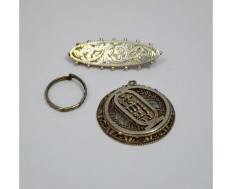 THREE ITEMS OF JEWELLERY, to include a filigree pendant, an engraved brooch and a band ring (s.d.)