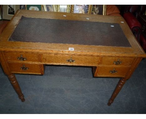 AN OAK DESK, with five drawers and leather inlay top 