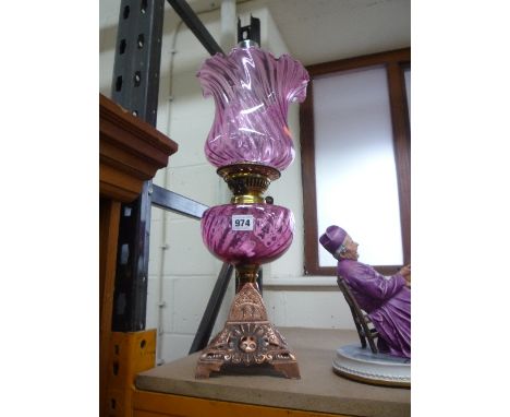 A BRASS/COPPER OIL LAMP, with cranberry coloured well and shade