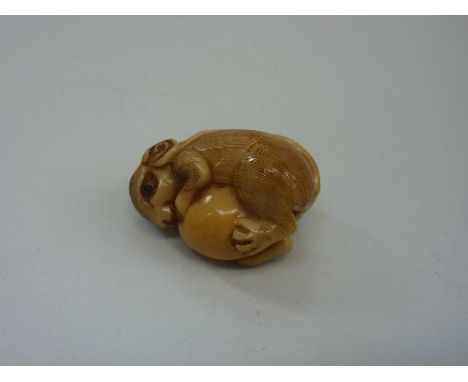 A NETSUKE, depicting a small mouse holding onto a nut, characters to the top of the head