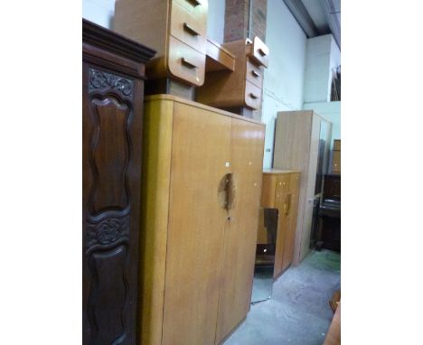 A LIGHT OAK THREE PIECE BEDROOM SUITE, comprising of a two door wardrobe, dressing table with mirror and a gents two door war