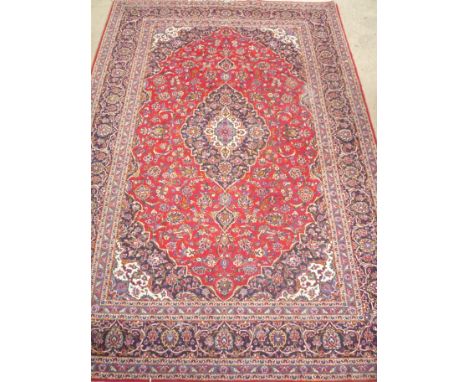 A BLUE AND RED GROUND PERSIAN CARPET, approximate size 366cm x 244cm