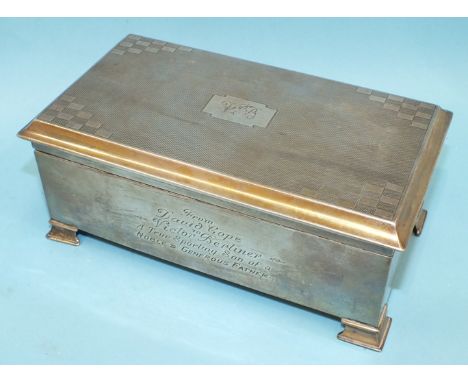 A rectangular engine-turned cigarette box on bracket feet, 18cm wide, Birmingham 1933.