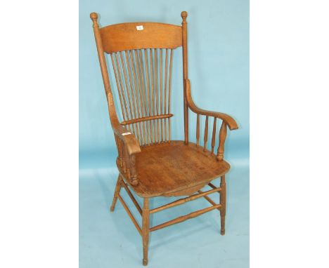 An oak and elm rustic open-back kitchen chair, the stick back and galleried arms with solid seat, on turned legs.