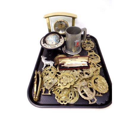 A tray containing a quantity of horse brasses, brass nut cracker, miniature globe on stand, a rolled gold yard o' lead mechan