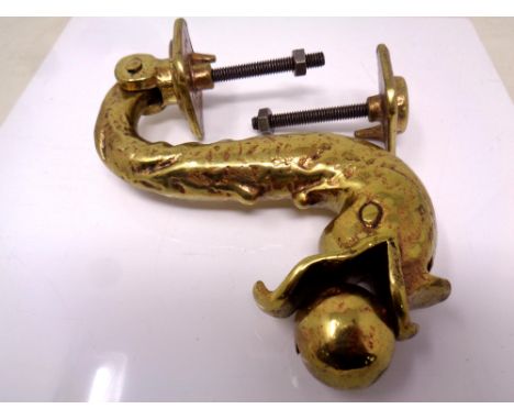 An ornate brass fish door knocker.