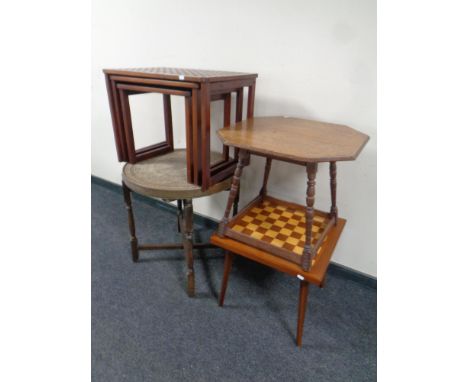 An Edwardian octagonal carved oak occasional table together with a eastern brass topped table on folding stand, a nest of thr