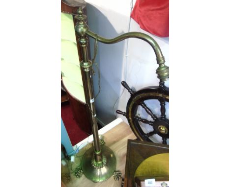 An Early 20th Century Brass Rise and Fall Reading Standard Lamp, having a platform base and claw feet.
