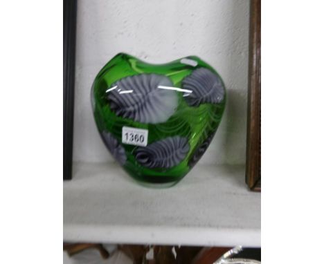 A green art glass vase decorated with leaves