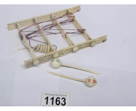 A carved ivory 'loom' shelf
