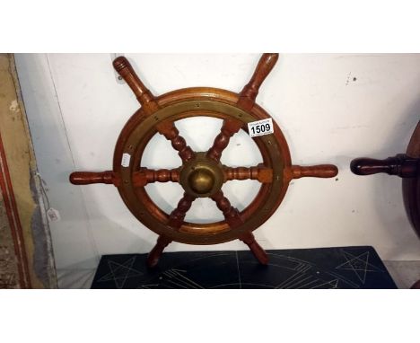 A brass bound light mahogany ships wheel marked V.M.Ball