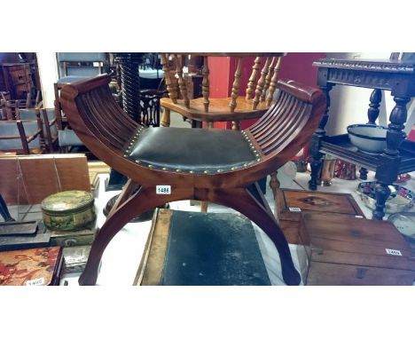 A mahogany piano stool with leather seat