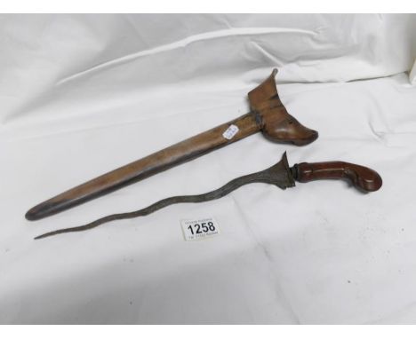 An Indonesian Kriss dagger with carved wooden hilt and wooden scabbard