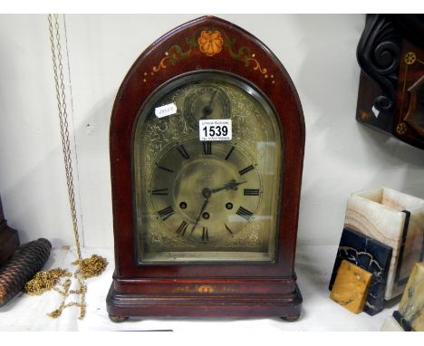 A dark stained with painted decoration bracket clock with silvered face and Westminster chime
