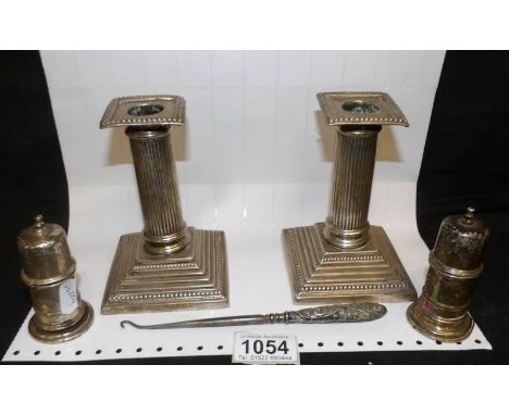 A pair of silver candlesticks, 2 silver condiments and a silver handled button hook