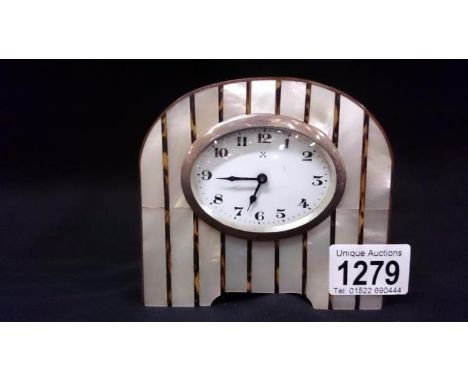 A mother of pearl mantel clock with oval silver rim