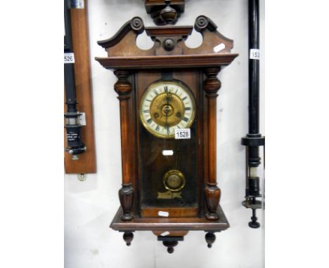 A wall clock with pendulum and key