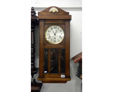 A 1930's oak wall clock with bevelled glass panels