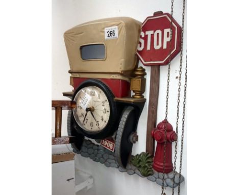 A decorative wall clock in the shape of the back of a vintage car