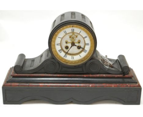 A late Victorian slate drum head mantel clock, having enamelled dial with Roman numerals and eight day cylinder movement