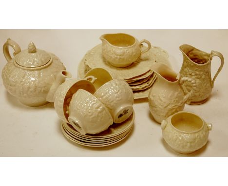 A Belleek part tea service, having relief decoration of figures and berries; together with a similar cream jug and other teaw