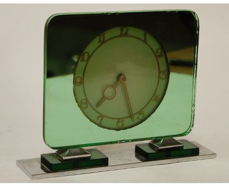 An Art Deco green glass mantel clock on a rectangular chrome base
