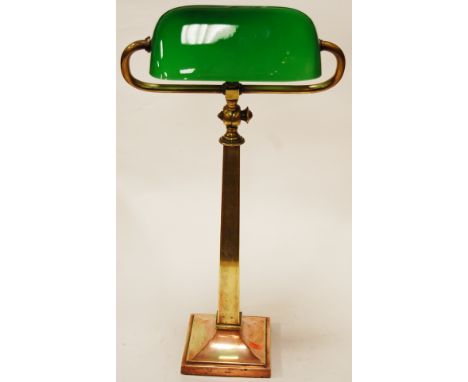 An early 20th century adjustable desk lamp having a later green glass shade on a brass column and square copper base