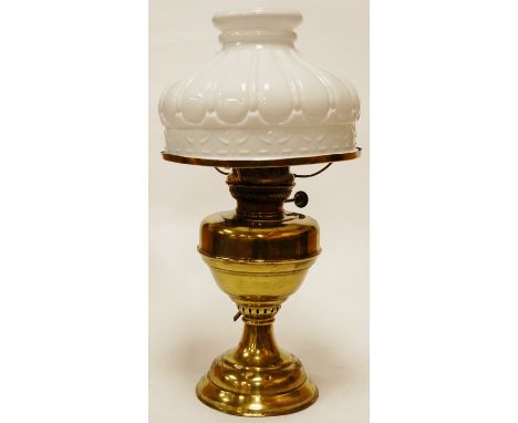 An early 20th century brass pedestal oil lamp, having opalescent glass shade, later converted to electricity 