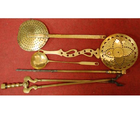 A small collection of brassware to include fire tools, chestnut roasters etc