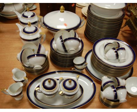 A continental porcelain part tea and dinner service on a white ground with blue borders, heightened in gilt to include side p