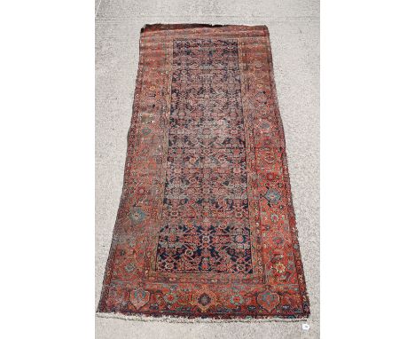 Middle Eastern red ground carpet of geometric design, 310 x 142cm 