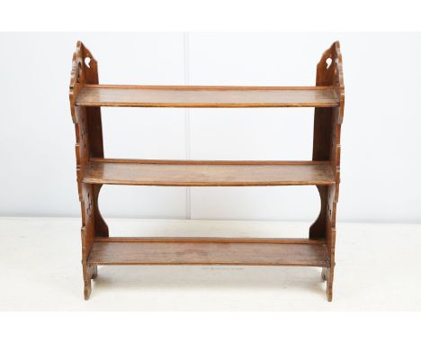 Early 20th century mahogany three tier hanging shelf, each end carved with a stylised floral design, 63.5cm high x 62.5cm wid