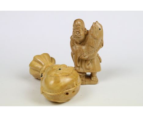 Two Chinese carved wooden netsuke to include a figure of an oriental man holding fish. 