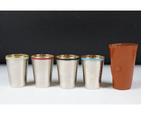 Set of four stacking silver plate &amp; Harlequin enamel stirrup cups with gilt lined interiors, contained in their brown lea