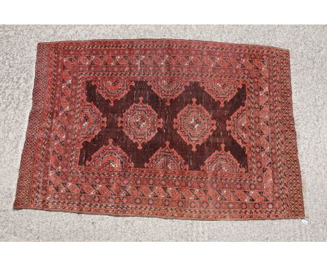 Middle Eastern red ground carpet, with two central medallions within geometric borders, 216 x 140cm 