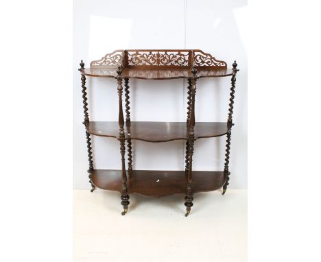 Early 20th century rosewood carved three tier shelf, with raised fretwork galleried back above spiral and turned supports, on