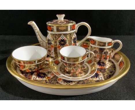 A Royal Crown Derby 1128 Imari pattern miniature tea set, comprising teapot, cream jug, sugar bowl, cup and saucer, on oval t