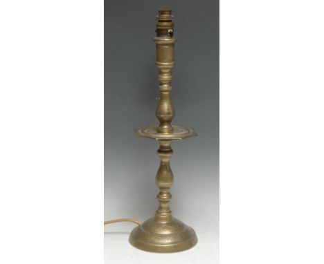A 19th century Indian/Middle Eastern brass candlestick, knopped pillar, shaped dip pan, domed base, chased with bands of leaf
