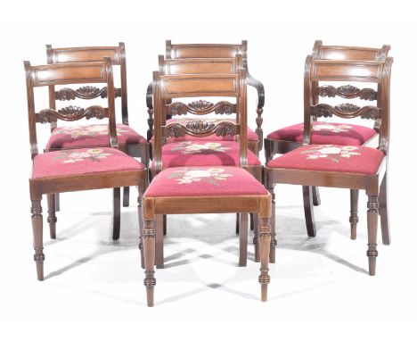 A set of seven George IV mahogany dining chairsEach with a concave top rail above a scrolling foliate rail and a tapestry dro