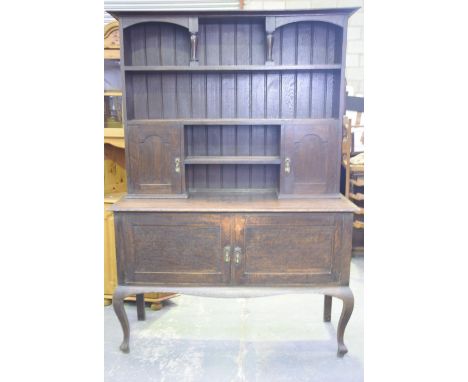A 17th Century style oak dresser, circa 1920 The high back with an arcaded top shelf above a pair of fielded panelled spice c