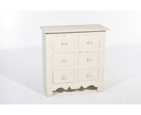 A rustic painted hardwood chest 
With an arrangement of six deep drawers each with knob handles above a shaped apron raised o