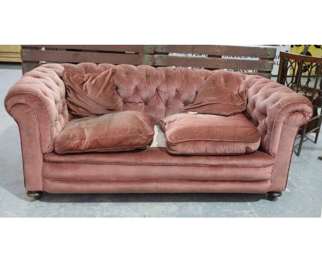 An early 20th Century pink valour Chesterfield type settee
With a deep set padded and button back scroll arm enclosing two lo