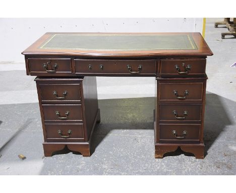A reproduction mahogany twin pedestal serpentine deskThe serpentine moulded top inset with a green leather and gilt tool writ