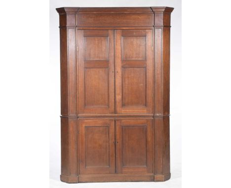 A George III oak flat front free standing corner cupboard
The upper cabinet with a moulded cornice above a pair of panelled c
