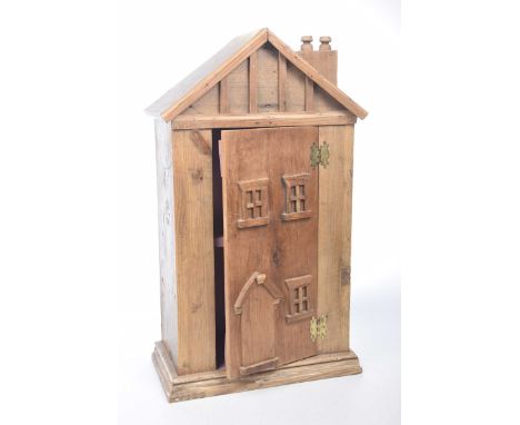 A rustic carved hardwood house form cabinetThe small scratch built cabinet of architectural form, the door opening to reveal 