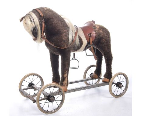 A vintage 1960's child's pull along toyThe flush horse figure adorned with saddle mounted on a metal frame with four tubular 